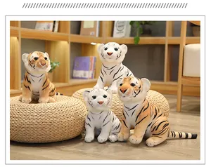 Cuatro lindos peluches de tigre blancos y amarillos sobre pufs de mimbre en un hogar acogedor