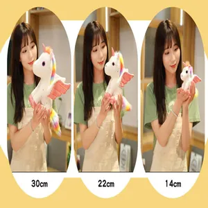 Tre dimensioni di peluche unicorno angelo in 30cm, 22cm e 14cm tenuti da una modella