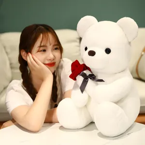 Soft white plush teddy bear holding a red fabric rose, ideal gift for Valentine's Day romance.