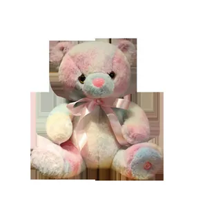 Detailed view of colorful tie-dye glowing teddy bear plush toy with pink silk ribbon