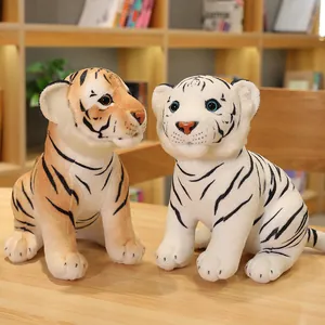 Lindos peluches de tigre naranja y blanco sentados sobre una mesa de madera clara.