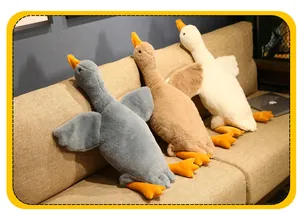 Primer plano de tres almohadas de peluche de ganso gigante en gris marrón y blanco