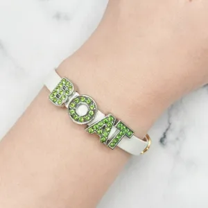 Dettaglio di lettere in strass verde da 8 mm su un braccialetto bianco DIY