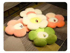 Detalle de cojines de felpa coloridos en forma de flor con bordados lindos.
