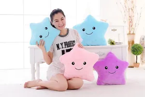 Femme asiatique assise tenant des coussins en peluche colorés en forme d'étoile dans une pièce