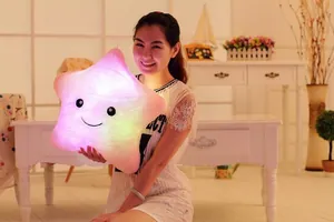 Coussin en peluche étoile lumineuse avec LED colorées, tenu par un mannequin asiatique