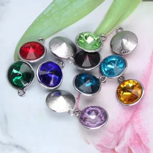 Macro view of twelve colorful birthstone pendants with silver frames for DIY crafts