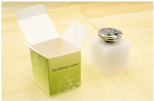 Close-up van levensboom auto diffuser locket met verpakkingsdoos op stoffen achtergrond