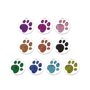 Detailed view of ten colorful glitter paw print pet ID tags in various metallic shades
