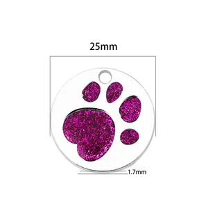 Detailed view of a 25mm metal pet identity tag with a purple glitter dog paw print design