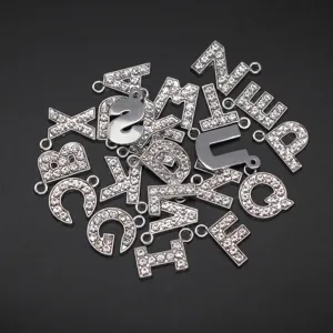 Nahaufnahme von 15 mm silbernen Buchstabenanhängern mit funkelnden weißen Strasssteinen