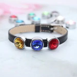 Detailed view of DIY black leather wristband with faceted yellow, blue, and red birthstone charms.