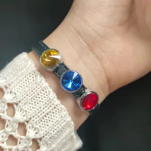 Detail shot of a black bracelet with yellow, blue, and red faceted crystal stones
