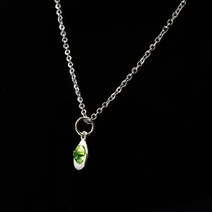 Close-up of alloy waterdrop pendant with faceted green birthstone