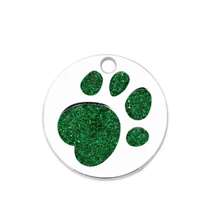 Detailed close-up view of a metal pet ID tag featuring a vibrant green glitter paw print
