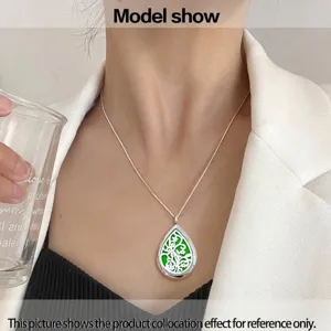 Model wearing a silver waterdrop hollow aromatherapy diffuser necklace with a green pad.