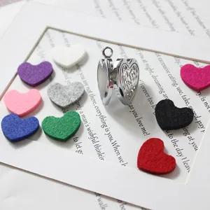 Detail of 30mm heart-shaped filigree locket with colorful aroma diffuser felt pads