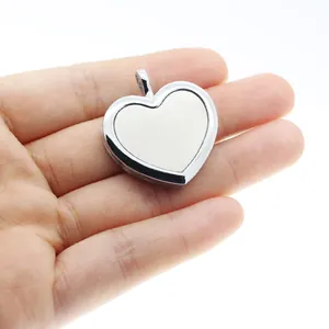 Detailed view of silver heart-shaped aromatherapy diffuser pendant held in hand