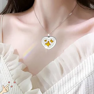 Detailed view of a stainless steel heart-shaped aromatherapy necklace worn by a model