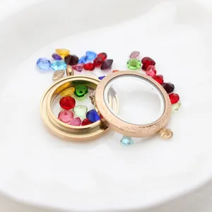 Close-up view of a 25mm gold stainless steel glass locket pendant with colorful charms