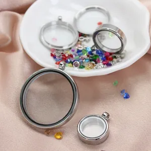Close-up detail of round stainless steel glass lockets in multiple sizes on pink silk