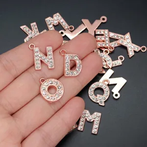 Detaillierte Ansicht von 15mm Strass-Alphabet-Anhängern in Roségold für DIY-Schmuckprojekte.