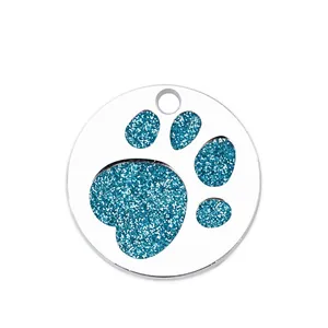 Detailed macro view of the glitter paw print pattern on this metal pet identification tag