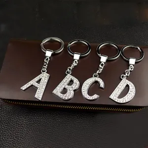 Close-up detail of silver alphabet keychains A to D with sparkling rhinestones.