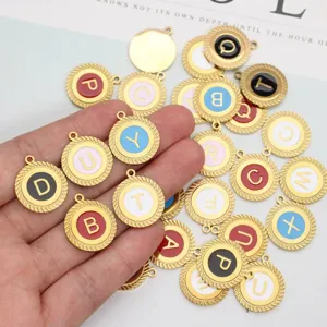Detailed macro view of gold-plated stainless steel scalloped enamel alphabet charms