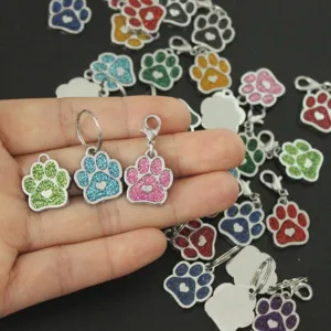 Gros plan de pendentifs d'identification pour animaux en forme de patte pailletée