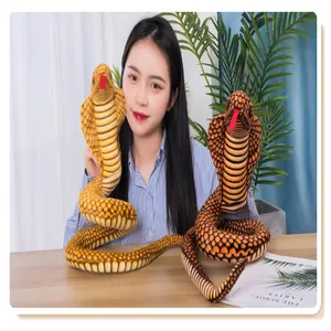 Realistic coiled cobra plush toy prank doll held by a woman in a lifestyle setting