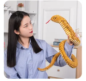 Realistic yellow cobra plush toy held by a model to show its large scale and flexible body