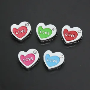 Close-up of 8mm colorful heart charms with LOVE engraving and small crystals for DIY