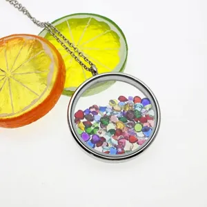 Close-up of a silver round glass locket filled with multi-colored heart birthstones