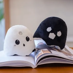 Close-up detail of reversible ghost plush toy showing white and black expressions