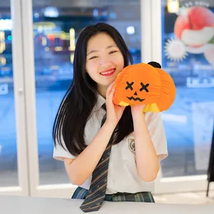 Ragazza sorridente che tiene un peluche di zucca di Halloween reversibile in dettaglio