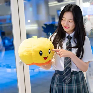 Simpatico peluche a forma di zucca reversibile tenuto da una modella per Halloween