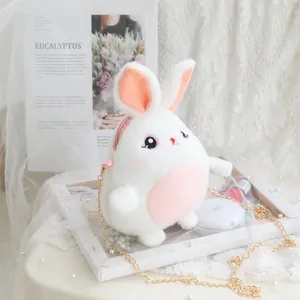 Detalle de un lindo bolso bandolera de conejo de peluche blanco con cadena dorada