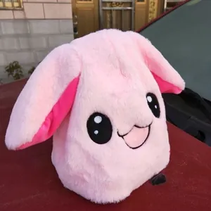 Primo piano di un simpatico cappello da coniglio in peluche rosa con grandi occhi.