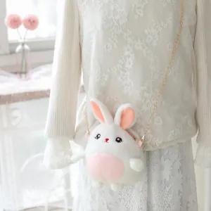 Primer plano de un bolso bandolera de peluche de conejo con una elegante cadena dorada