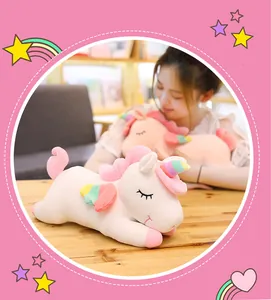 Detailed view of the soft white plush unicorn toy with rainbow horn and wings