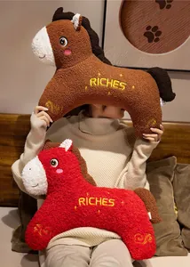 Dettaglio di due simpatici cuscini di peluche a forma di cavallo rosso e marrone