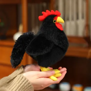 Peluche coq noir doux tenu dans les mains, montrant son design potelé et mignon