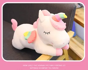 Detailed side view of soft white plush unicorn doll showing rainbow wings and horn