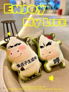 Macro view of two humorous cow emoji plush pillows showcased in a warm cafe interior decor