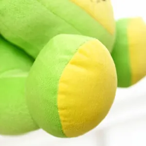 Detail view of a soft cartoon frog plush toy featuring vibrant green and yellow plush fabric