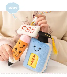 Close-up of cute plush exam success pencil and graduation book keychains