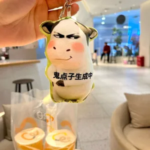 Close-up detail of a funny plush cow keychain featuring a unique tricky expression.