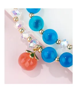 Close-up of blue agate and crystal beads with a delicate peach heart charm for women.