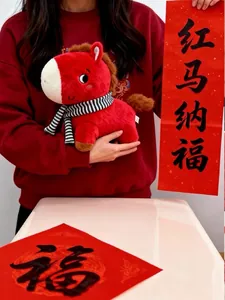 Primer plano de un peluche de caballo rojo festivo con bufanda a rayas para el Año Nuevo